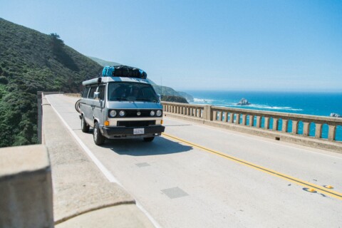 van driving along a bridge by the coast